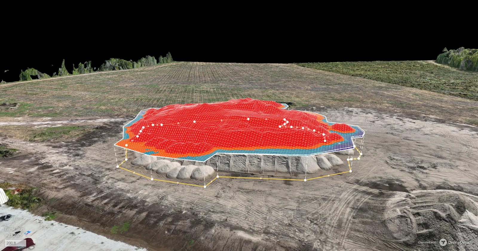 DroneDeploy 3D volume measurement of a sand stockpile captured by VSD Pros, a red elevation mesh overlays the pile with the measured base outline drawn around it
