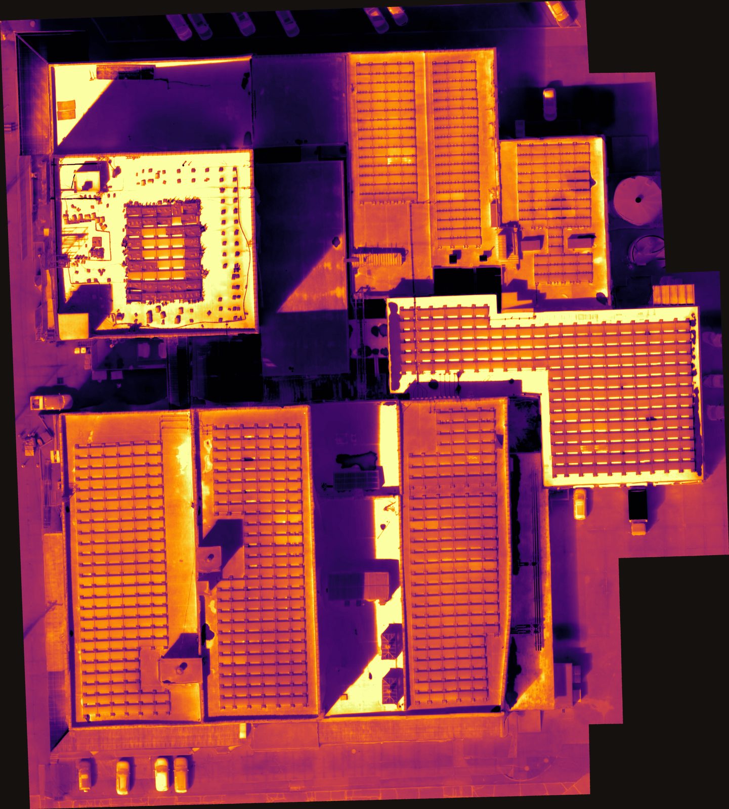 Radiometric thermal orthomosaic map of an entire commercial building complex captured by VSD Pros, showing rooftop solar arrays panel by panel in a heat palette